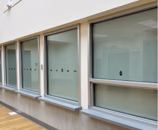 Three modern sliding aluminum windows with frosted or obscured lower panes, set into a light-colored wall, possibly in a bathroom or a similar interior space.
